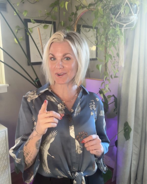 Brooke Bishop speaking and gesturing in a room with plants and framed art